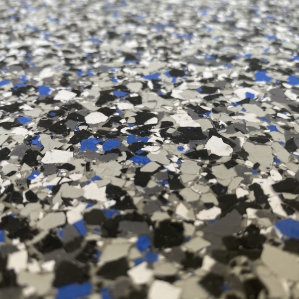 Close-up image of a speckled, multi-colored surface with small fragments of blue, white, black, and gray hues.