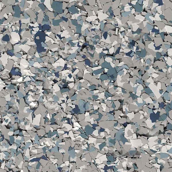 This image shows a close-up of a surface covered with multi-colored chips in shades of gray, blue, and white, typical of a decorative floor coating.