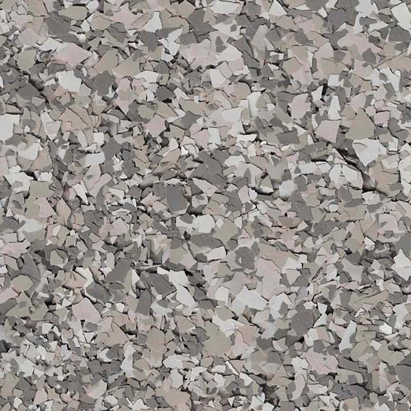 The image displays a close-up of a textured surface with various shades of gray and beige flakes, resembling granite or terrazzo flooring.